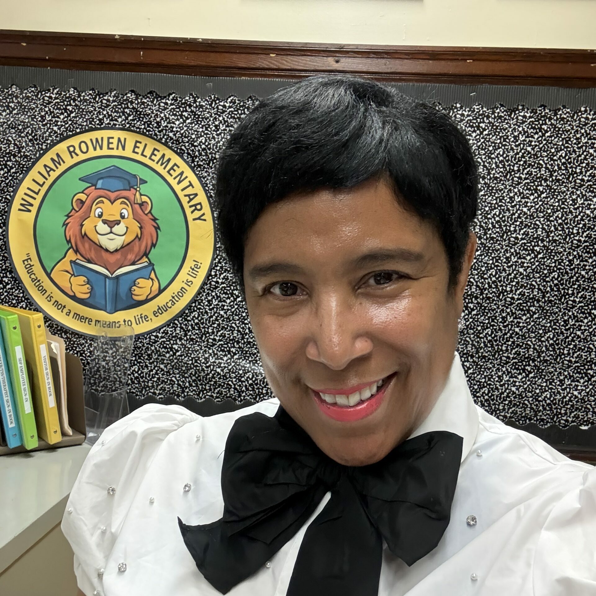 Angela Ryans, Principal of William Rowen Elementary School, smiling in front of the school’s lion emblem.